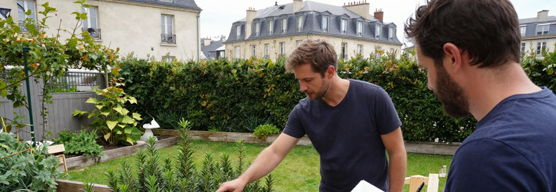 Jardinier présentant estimation travaux à client dans jardin parisien 12ème arrondissement