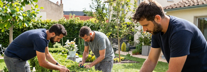 Jardiniers Marseille 15 Services Multiples Trois jardiniers professionnels marseillais travaillant simultanément : taille de haie, tonte de pelouse et installation d'arrosage automatique dans un jardin du 15ème arrondissement.